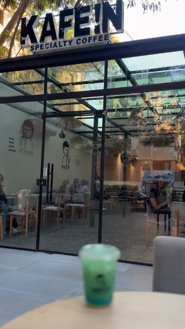 A cold green drink on a table in the glass room