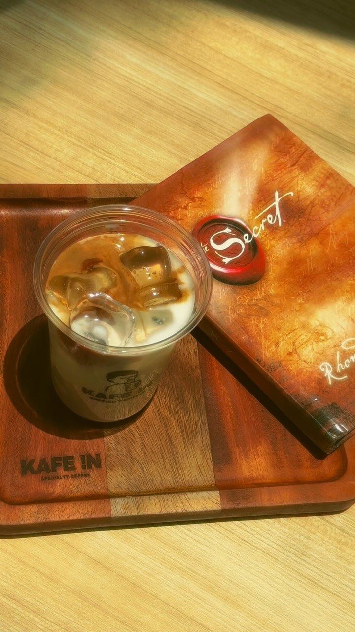 An iced latte on a wooden KAFE !N tray